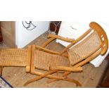 An antique folding steamer chair with cane work seat and backrest