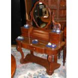 A Victorian mahogany Duchess dressing table with seven drawers to the top and shaped mirror