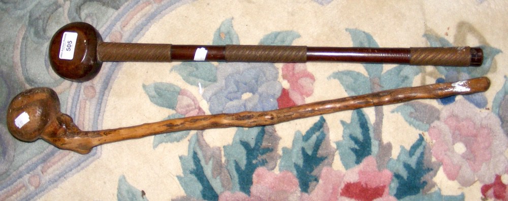 An old African carved wooden club, together with one other