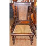 An oak armchair with cane work seat and backrest