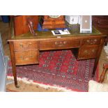 An antique oak writing desk with five drawers to the front and green leather top - 120cm wide