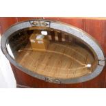 A decorative oval metal wall mirror