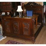 A decorative antique carved French oak bedstead, the carved headboard depicting musicians - 144cm