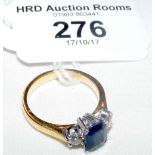 An unhallmarked yellow metal three stone sapphire and diamond ring