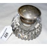 A 9cm diameter ribbed cut glass desk inkwell with silver mount and hinged lid