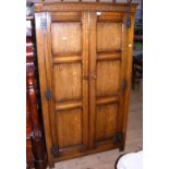 An oak hall wardrobe enclosed by a pair of panelled doors