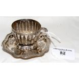 An oriental silver fluted cup with dragon handle, standing on shaped hexagonal stand with