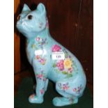 A 31cm high pottery dog with glass eyes and transfer printed flower decoration
