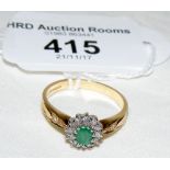 An emerald and diamond ring in gold setting