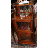 An antique music cabinet with carved front and galleried top