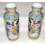 A pair of oriental vases depicting domestic archery scenes - 35cm high - with signature to base