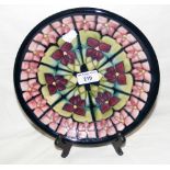 A Moorcroft pottery plate with piped floral decoration - 26cm diameter - with mark to base