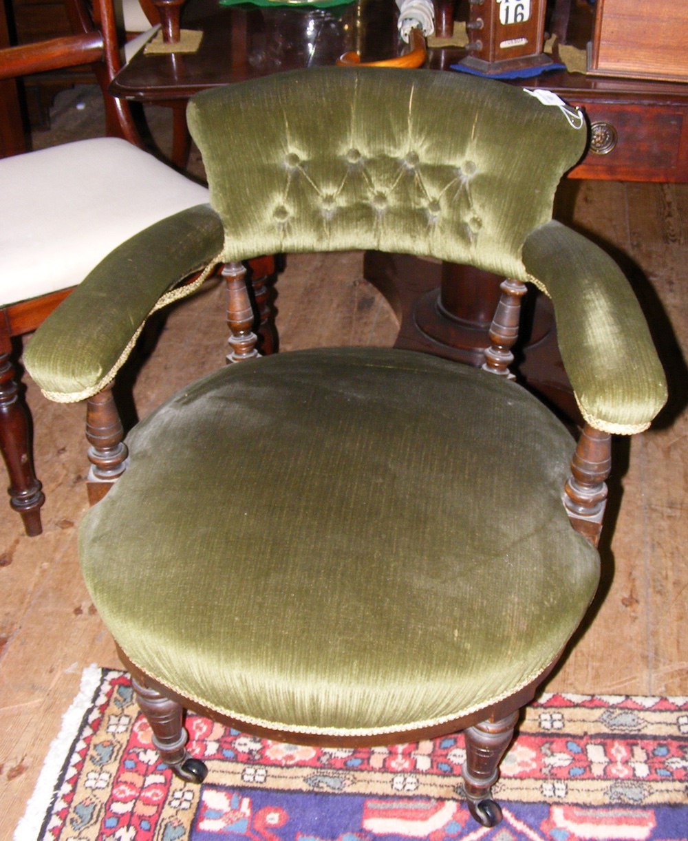 A Victorian tub chair with button back and turned front supports