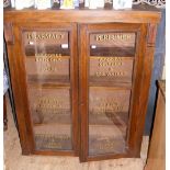 A Pharmacist's antique display cabinet with writing to the glazed doors