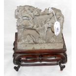 A carved stone Dog of Fo on elaborate wooden stand - 24cm high