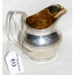 A silver Georgian cream jug with engraved decoration - 11cm high