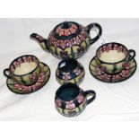 A Moorcroft pottery teaset comprising teapot, milk jug, sugar bowl, two cups and saucers - floral