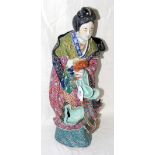 A 44cm high ceramic Chinese maiden with vibrant painted glaze and impress mark to the base