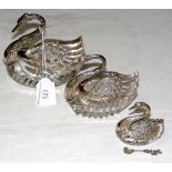 A set of graduated silver and cut glass swans - table salts