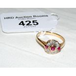 A ruby and diamond cluster ring in 14ct gold setting