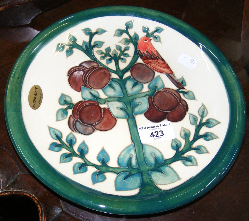 A Moorcroft pottery plate with bird in tree decoration - 26cm diameter - with mark to base