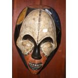 A carved wooden African tribal mask with painted face - 38cm