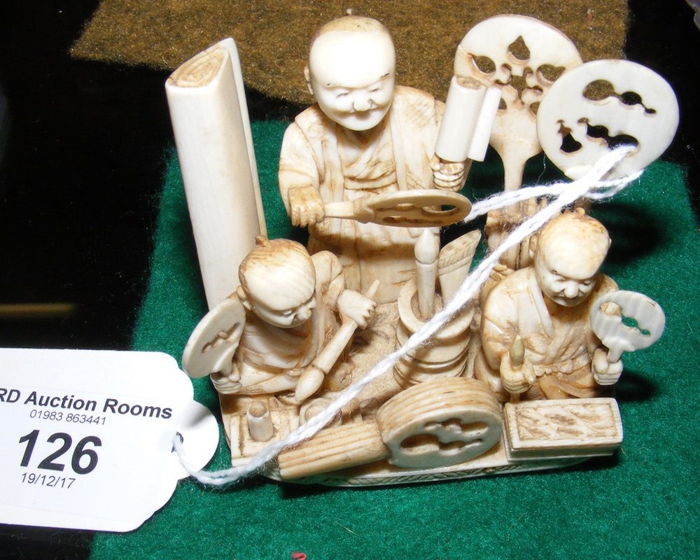 A carved ivory figural group of men in workshop - 6.5cm high