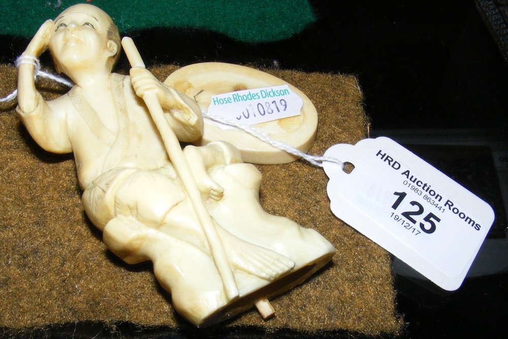 A 10cm high carved ivory figure - man holding staff