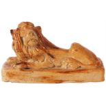 An early 19th Century Staffordshire type salt glazed Stoneware model of a recumbent LION with