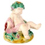 A 19th Century Worcester Polychrome FIGURE of a reclining Putti 8cm high