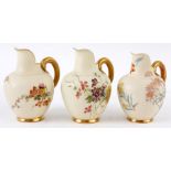 A GROUP OT THREE ROYAL WORCESTER GILT EDGED IVORY GROUND FLATBACK JUGS with gilded celery type