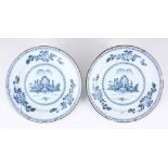 A PAIR OF 18TH CENTURY ENGLISH BLUE AND WHITE DELFT PLATES with landscape centres and leafing flower