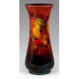 A WILLIAM MOORCROFT SLENDER BALUSTER VASE tube lined and decorated in the leaf and berry pattern