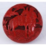 A 19TH CENTURY CINNABAR CIRCULAR FINELY CARVED PENDANT depicting figures and a donkey in a tree