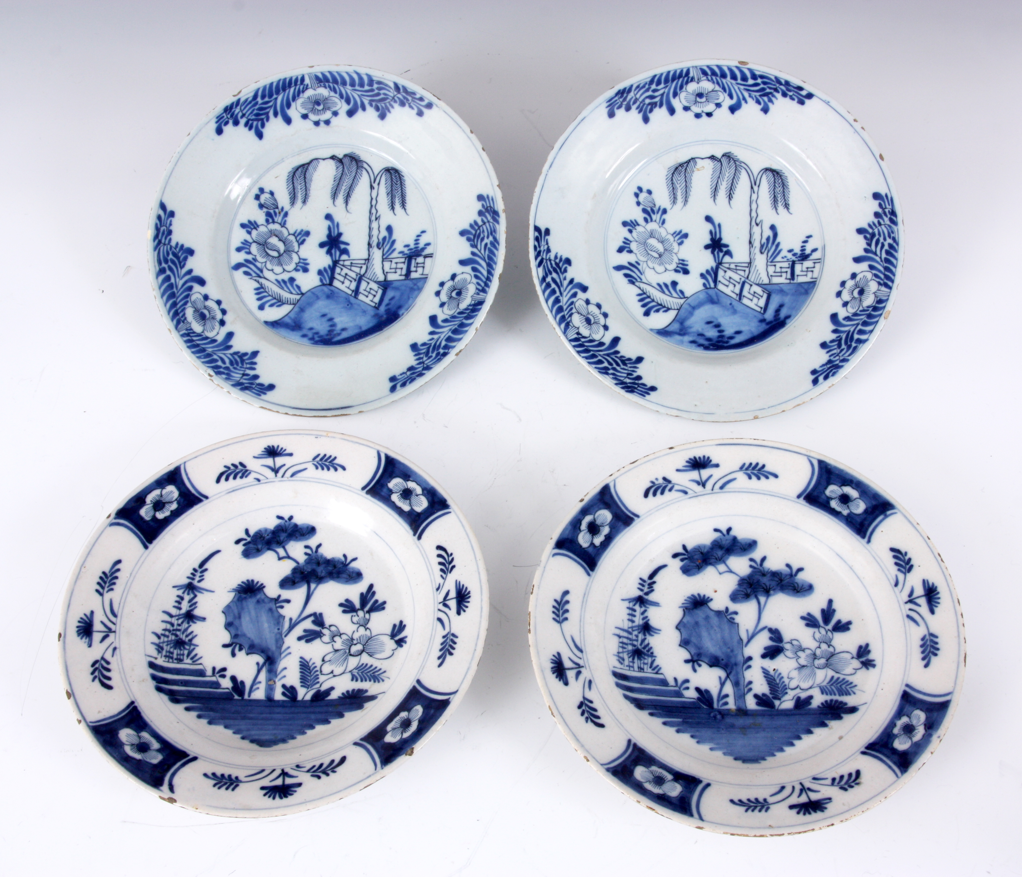 TWO PAIRS OF 18TH CENTURY DUTCH DELFT PLATES with tree lined landscape centres and floral panelled