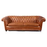 A 19th CENTURY STYLE TAN LEATHERED THREE SEATER CHESTERFIELD SETTEE with button back and two loose