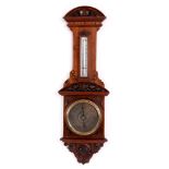 A LATE 19TH CENTURY WALNUT ANEROID BAROMETER with elaborate carved case, engraved silvered dial