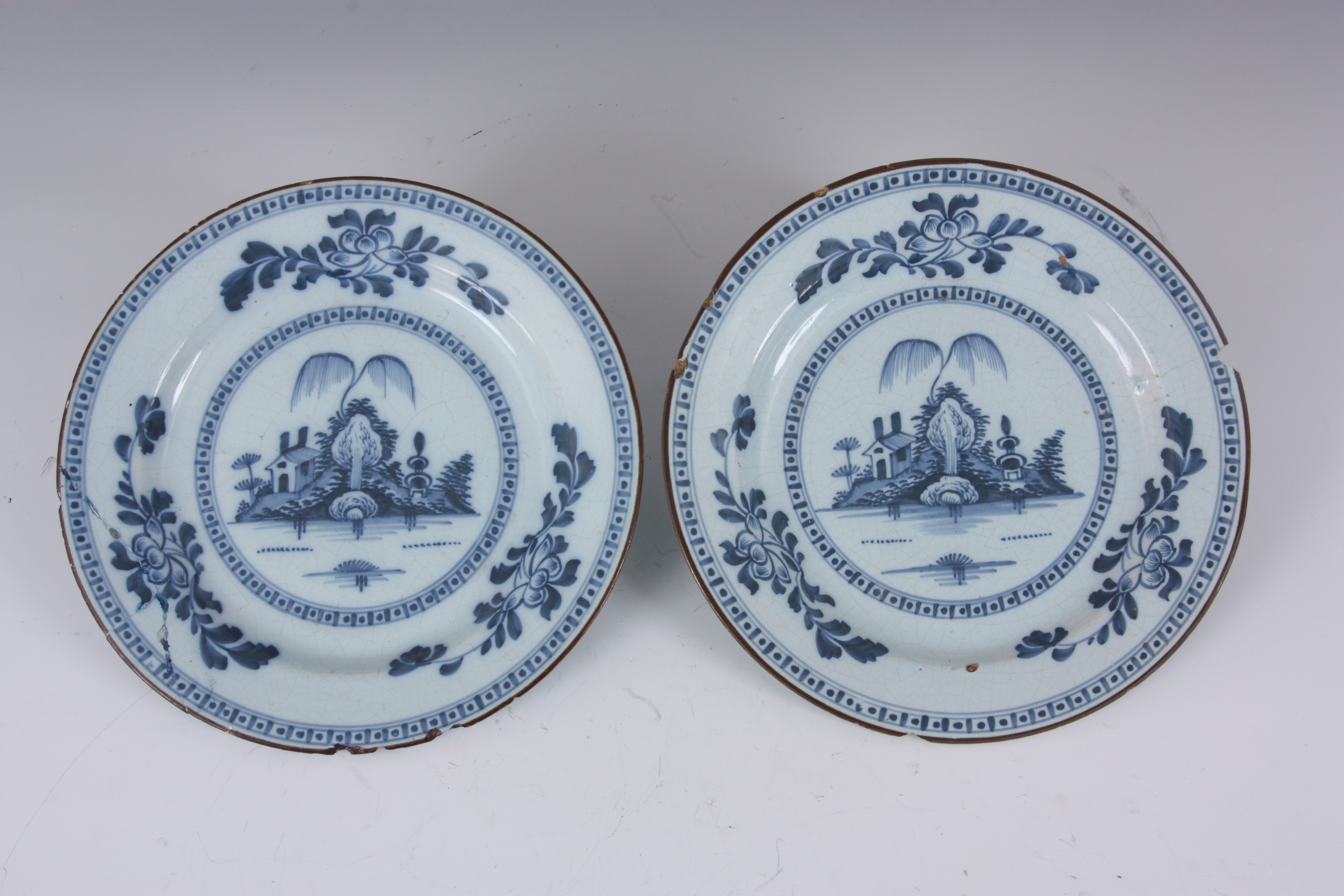 A PAIR OF 18TH CENTURY ENGLISH BLUE AND WHITE DELFT PLATES with landscape centres and leafing flower - Image 10 of 10