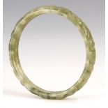 AN ORIENTAL JADE BANGLE with pierced and scrollwork decoration.