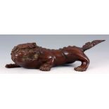 A LATE 19TH CENTURY CHINESE CARVED HARDWOOD CROUCHING FOO DOG 39cm wide.