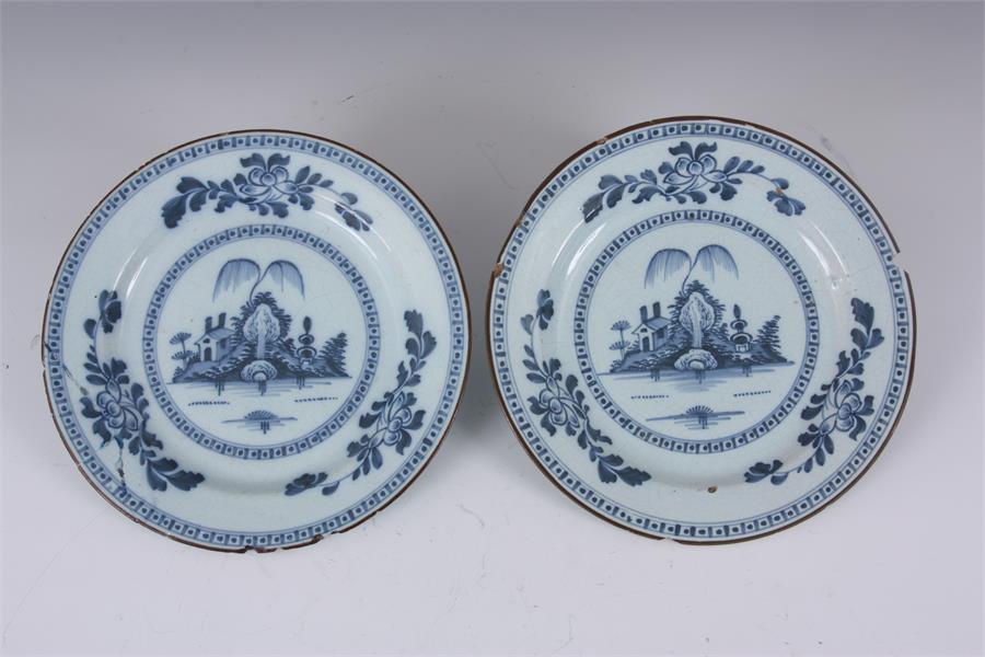 A PAIR OF 18TH CENTURY ENGLISH BLUE AND WHITE DELFT PLATES with landscape centres and leafing flower - Image 6 of 10