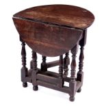 A MID 18TH CENTURY SMALL OAK GATE LEG TABLE with oval drop leaf top above a turned leg base frieze