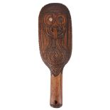 A 19TH CENTURY CARVED WOODEN MAORI CLUB with mask decoration and inlaid with halitosis shell eyes (