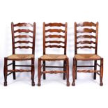 A SET OF SIX 19TH CENTURY ELM LADDER BACK DINING CHAIRS with rushed seats turned legs and joined