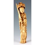 AN ANTIQUE CHINESE IVORY CARVING depicting a diety holding a sword and flower dressed in elaborate