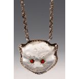 A CHINESE ROCK CRYSTAL PENDANT formed as a cats mask with coral eyes mounted in silver metal frame