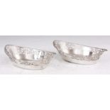 A PAIR OF EARLY 20th CENTURY SILVER BONBON DISHES of boat shape form with pierced scroll and leaf-