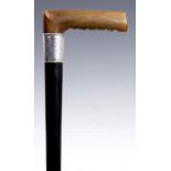 AN EARLY 20th CENTURY RHINOCEROS HORN HANDLED WALKING STICK with ebonised cane and silver collar