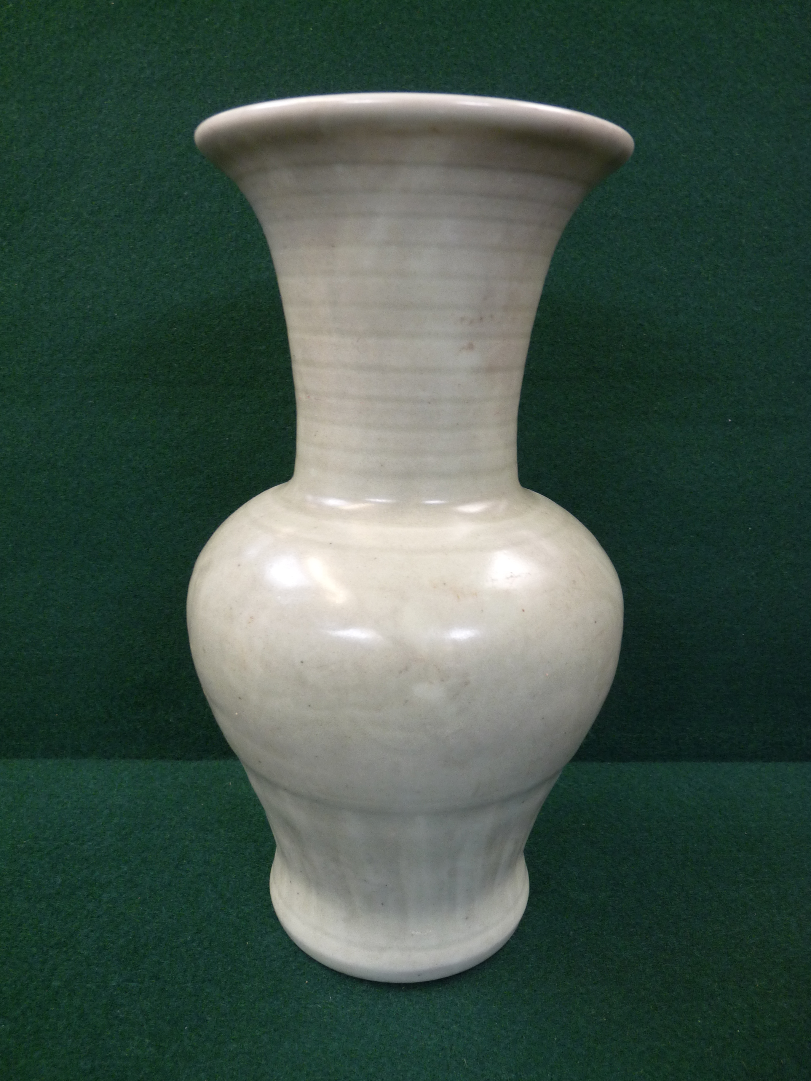 Chinese Celadon vase with banded neck above scroll baluster in green glaze, unglazed base, 26cm in