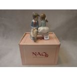 Boxed Nao figure of a boy and girl on a bench